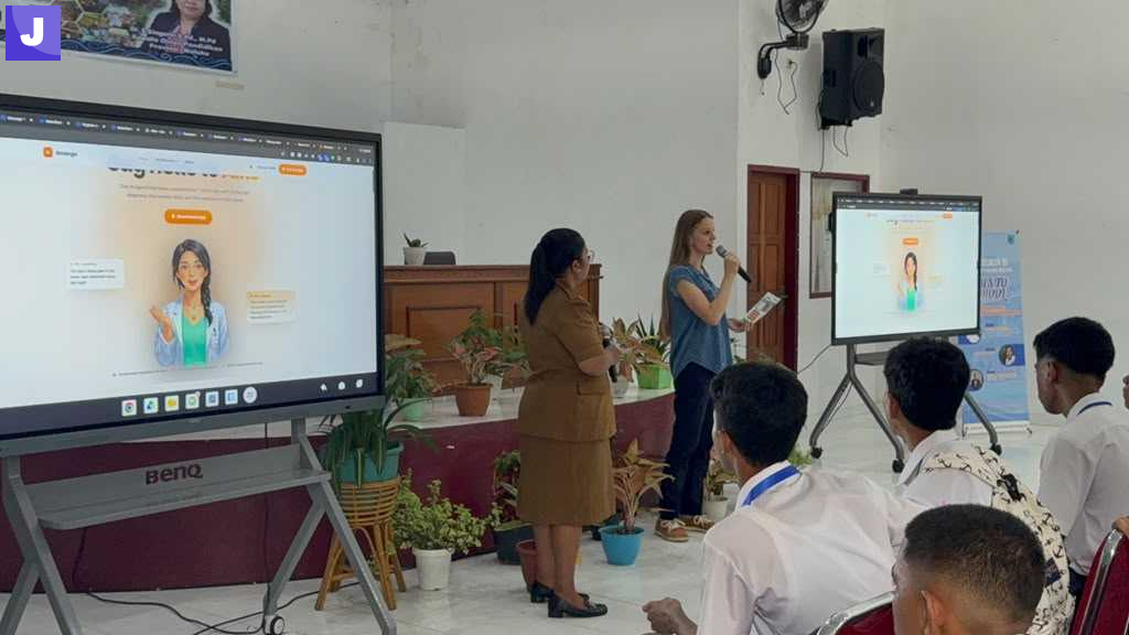 A Gmango presenter showing the Aiko assistant on a classroom screen to students at SMA Negeri 2 Ambon